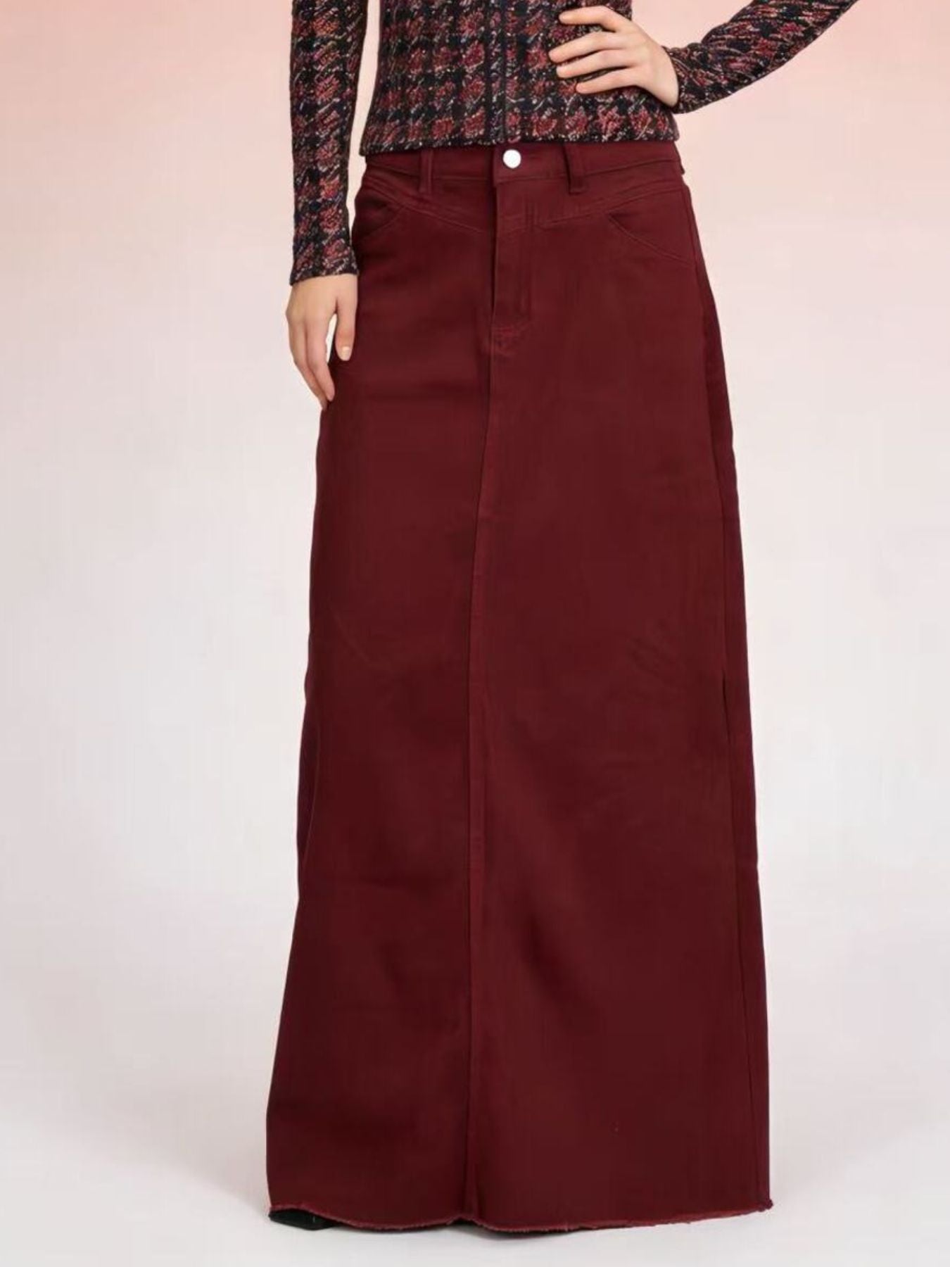 Raw hem maxi denim skirt with front button closure in burgundy, 85% cotton / 15% polyester blend.