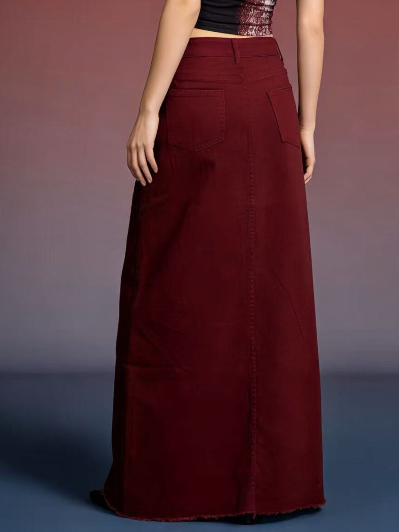 Back view of burgundy raw-hem maxi denim skirt with pockets and front button closure, 85% cotton / 15% polyester.