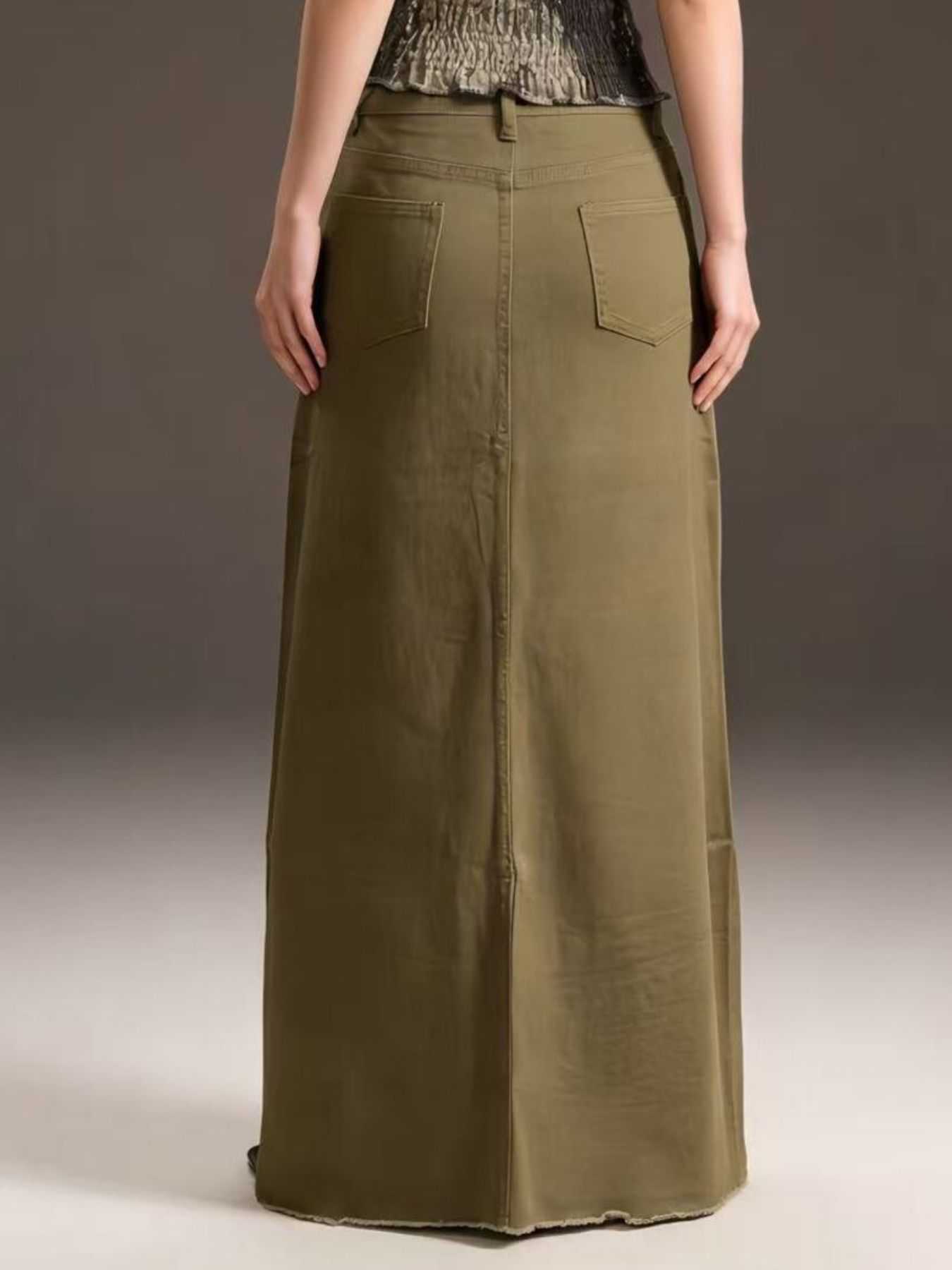 Back view of olive raw-hem maxi denim skirt with back pockets; 85% cotton / 15% polyester.