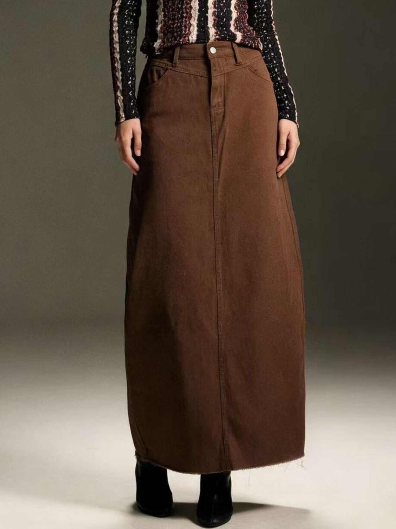 Raw hem maxi denim skirt with front button closure in brown, 85% cotton / 15% polyester blend.